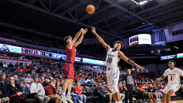 Nov 30, 2022; Cincinnati, Ohio, USA; N.J.I.T Highlanders guard Adam Hess (4) makes a three-point basket against Cincinnati Bearcats guard Rob Phinisee (10) in the second half at Fifth Third Arena. Mandatory Credit: Aaron Doster-USA TODAY Sports