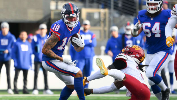 Dec 4, 2022; East Rutherford, New Jersey, USA; New York Giants wide receiver Isaiah Hodgins (18) runs with the ball as Washington Commanders safety Kamren Curl (right) defends during the first half at MetLife Stadium.