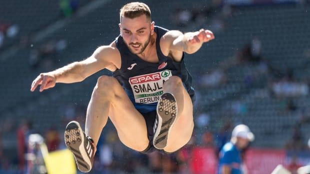 Albanian long jumper Izmir Smajlaj hangs in the air with his arms and legs outstretched during a jump.