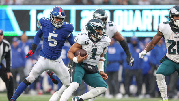 Dec 11, 2022; East Rutherford, New Jersey, USA; Philadelphia Eagles quarterback Jalen Hurts (1) scrambles for yards in front of New York Giants defensive end Kayvon Thibodeaux (5) during the first half at MetLife Stadium.
