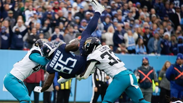 Tennessee Titans tight end Chigoziem Okonkwo (85) flips into the end zone for a touch down past Jacksonville Jaguars linebackers Devin Lloyd (33) and Josh Allen (41) during the first quarter at Nissan Stadium.