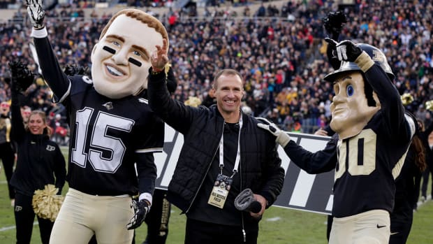 Purdue alumn and NFL quarterback Drew Brees waves to the stands during the fourth quarter of a game.