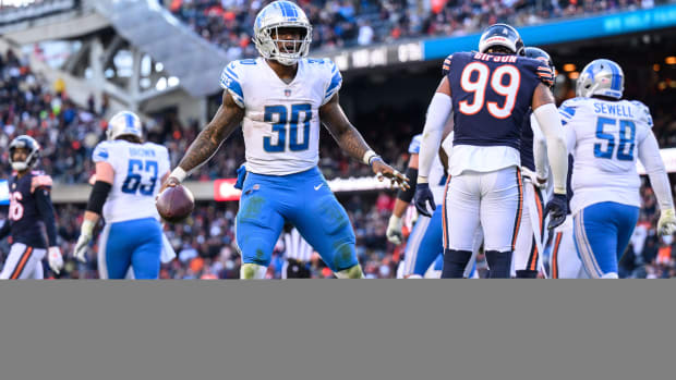 Detroit Lions running back Jamaal Williams celebrates his rushing touchdown, holding the ball in one hand with his arms out