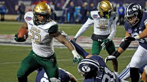 Dec 18, 2021; Shreveport, LA, USA; UAB Blazers running back DeWayne McBride (22) breaks a tackle against the BYU Cougars linebacker Max Tooley (31) during the fourth quarter during the 2021 Independence Bowl at Independence Stadium.