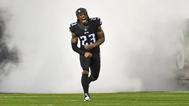 Philadelphia Eagles safety C.J. Gardner-Johnson runs onto the field yelling, with a cloud of smoke behind him