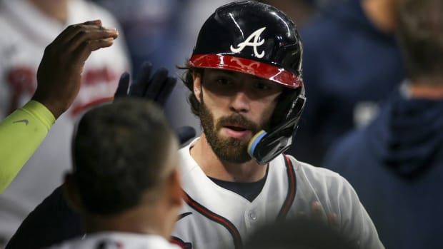 Braves shortstop Dansby Swanson high fives teammates in the dugout during a game vs. the Phillies.
