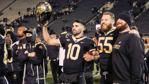 Nov 19, 2022; Winston-Salem, North Carolina, USA; Wake Forest Demon Deacons quarterback Sam Hartman (10) holds up his helmet during the singing of the school alma mater after the win against the Syracuse Orange at Truist Field.