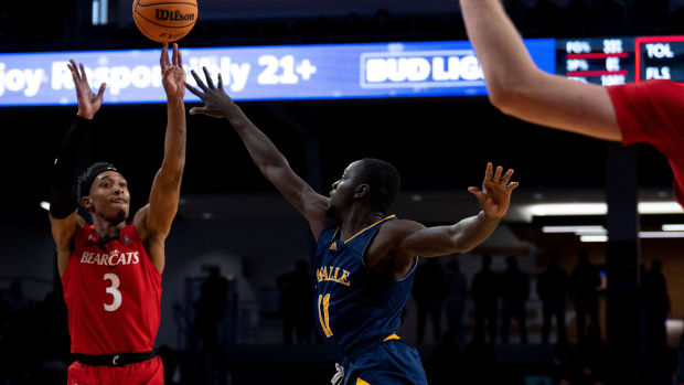 Cincinnati Bearcats guard Mika Adams-Woods (3) hits a 3-point shot over La Salle Explorers forward Fousseyni Drame (11) in the first half of the NCAA men s basketball game at Fifth Third Arena in Cincinnati on Saturday, Dec. 17, 2022. Ncaa Basketball La Salle Explorers At Cincinnati Bearcats Ac