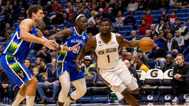 New Orleans Pelicans forward Zion Williamson (1) dribbles against Milwaukee Bucks guard Jrue Holiday (21) and center Brook Lopez (11)