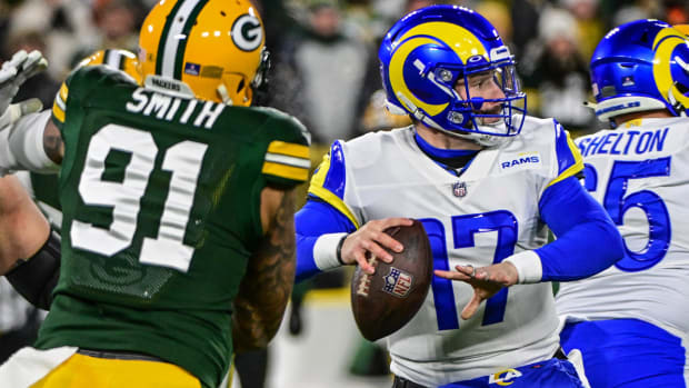 Dec 19, 2022; Green Bay, Wisconsin, USA; Los Angeles Rams quarterback Baker Mayfield (17) looks to pass while under pressure from Green Bay Packers linebacker Preston Smith (91) in the first quarter at Lambeau Field.