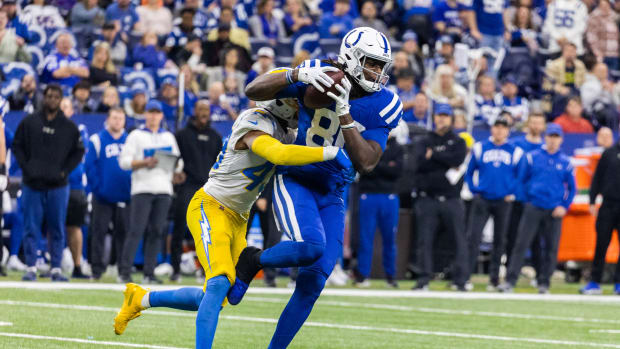 Dec 26, 2022; Indianapolis, Indiana, USA; Indianapolis Colts tight end Jelani Woods (80) runs with the ball while Los Angeles Chargers cornerback Michael Davis (43) defends in the first half at Lucas Oil Stadium.