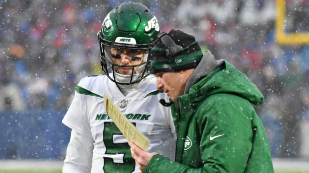 New York Jets offensive coordinator Mike LaFleur talks with quarterback Mike White holding a piece of paper