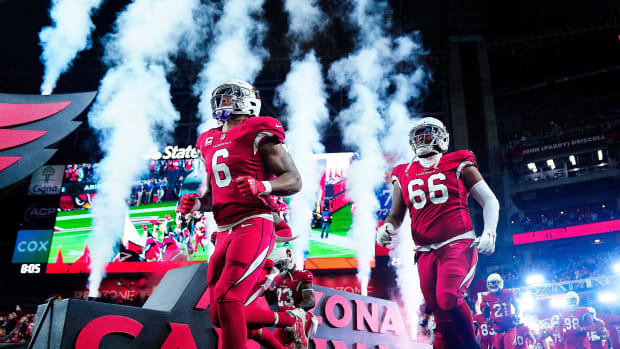 December 12, 2022; Glendale, Ariz; USA; Cardinals James Conner (6) and Wyatt Davis (66) take to the field against the Patriots at State Farm Stadium.