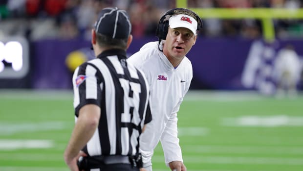 Ole Miss coach Lane Kiffin talks with an official about a penalty call during the first half of the team’s Texas Bowl.