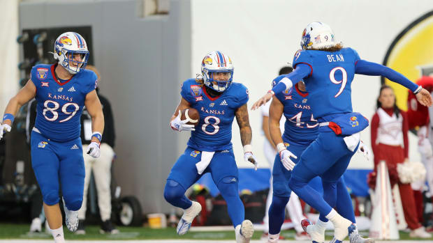 Dec 28, 2022; Memphis, TN, USA; Kansas Jayhawks running back Ky Thomas (8) celebrates with tight end Mason Fairchild (89) and quarterback Jason Bean (9) after catching a pass for a touchdown against the Arkansas Razorbacks in the first quarter in the 2022 Liberty Bowl at Liberty Bowl Memorial Stadium. Mandatory Credit: Nelson Chenault-USA TODAY Sports