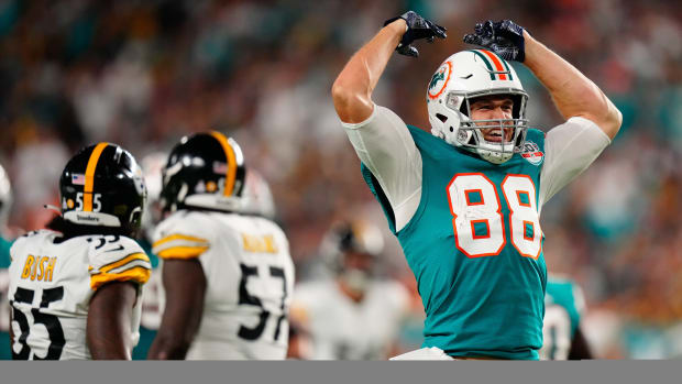 Miami Dolphins tight end Mike Gesicki throws his hands up in celebration