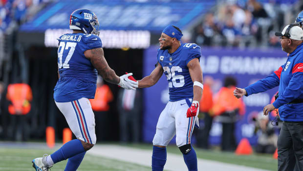 Jan 1, 2023; East Rutherford, New Jersey, USA; New York Giants defensive tackle Dexter Lawrence (97) celebrates a defensive stop with running back Saquon Barkley (26) during the second half against the Indianapolis Colts at MetLife Stadium.