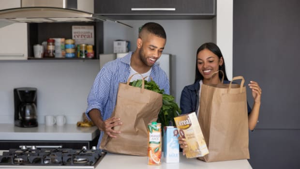 A man and woman in a kitchen unloading their grocery delivery service