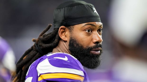 Vikings pass rusher Za'Darius Smith looks on while standing on the sidelines during a game.