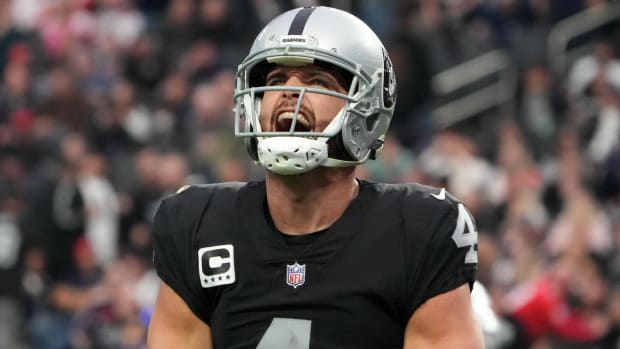 Raiders quarterback Derek Carr screams in celebration after a play during a game.