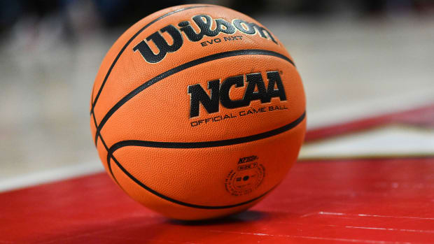 A basketball with the word “NCAA” on it sits on the floor