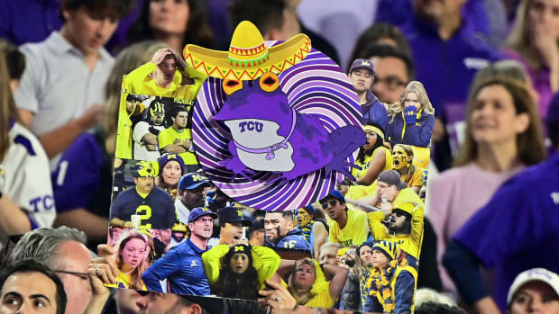 A fan holds a TCU Hypnotoad sign against Michigan