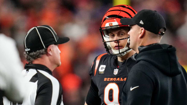 Cincinnati Bengals quarterback Joe Burrow (9) and head coach Zac Taylor speak with an official as the decision to suspend play is made in the first quarter of the NFL Week 17 game between the Cincinnati Bengals and the Buffalo Bills at Paycor Stadium in Downtown Cincinnati on Monday, Jan. 2, 2023. The game was suspended with suspended in the first quarter after Buffalo Bills safety Damar Hamlin (3) was taken away in an ambulance following a play. Buffalo Bills At Cincinnati Bengals Week 17