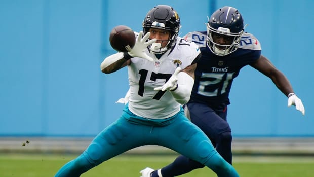 Dec 11, 2022; Nashville, Tennessee, USA; Jacksonville Jaguars tight end Evan Engram (17) pulls in a first down catch while defended by Tennessee Titans cornerback Roger McCreary (21) during the second quarter at Nissan Stadium.