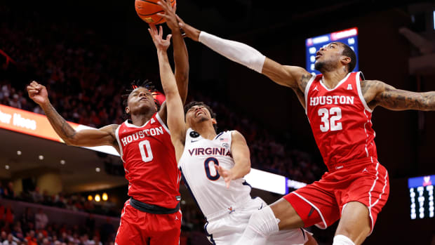 Dec 17, 2022; Charlottesville, Virginia, USA; Houston Cougars forward Reggie Chaney (32) and Cougars guard Marcus Sasser (0) block a shot by Virginia Cavaliers guard Kihei Clark (0) during the second half at John Paul Jones Arena. Mandatory Credit: Amber Searls-USA TODAY Sports