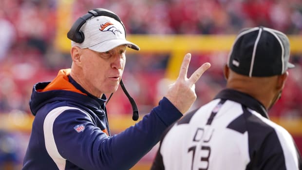 Denver Broncos interim head coach Jerry Rosburg talks to down judge Patrick Turner (13) against the Kansas City Chiefs during the first half at GEHA Field at Arrowhead Stadium.