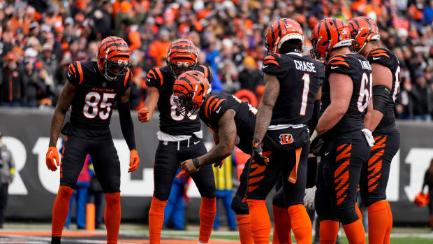 Cincinnati Bengals running back Joe Mixon (28) pulls a coin from his first band and flips it in the end zone after running in a touchdown in the first quarter of the NFL Week 18 game between the Cincinnati Bengals and the Baltimore Ravens at Paycor Stadium in downtown Cincinnati on Sunday, Jan. 8, 2023. The Bengals led 24-7 at halftime. Baltimore Ravens At Cincinnati Bengals Nfl Week 18