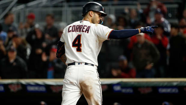 Minnesota Twins shortstop Carlos Correa points to his right with his back to the camera