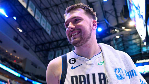 Mavericks guard Luka Doncic smiles while leaving the court after a game.