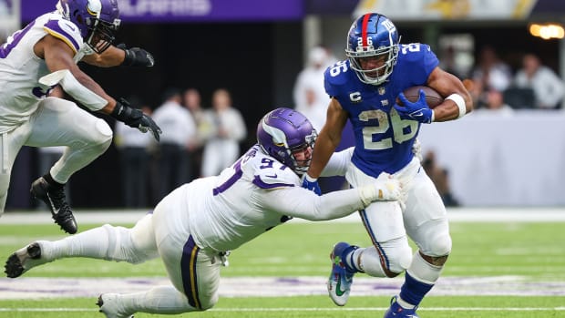 Dec 24, 2022; Minneapolis, Minnesota, USA; New York Giants running back Saquon Barkley (26) is tackled by Minnesota Vikings defensive tackle Harrison Phillips (97) during the fourth quarter at U.S. Bank Stadium.
