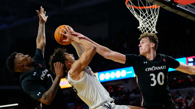 Cincinnati Bearcats forward Viktor Lakhin (30) blocks a shot by Xavier Musketeers guard Colby Jones (3) in the second half of the 90th Annual Crosstown Shootout NCAA basketball game between the Cincinnati Bearcats and the Xavier Musketeers at Fifth Third Arena in Cincinnati on Saturday, Dec. 10, 2022. The Musketeers held on down the stretch for a 80-77 win. Crosstown Shootout
