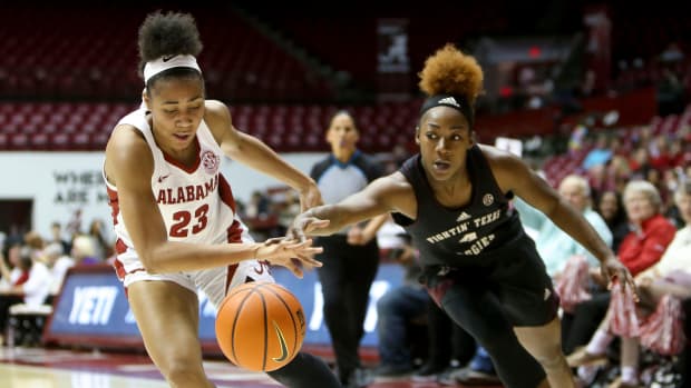 Alabama guard Brittany Davis (23) and Texas A&M guard Kay Kay Green (4) try to control the ball along the baseline at Coleman Coliseum in Tuscaloosa, Alabama. Ncaa Basketball Alabama Vs Texas A M