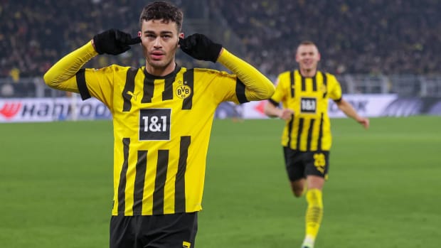Gio Reyna puts a finger in each ear to celebrate scoring a goal for Dortmund.