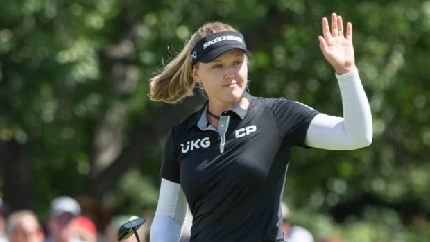 Brooke Henderson from Canada greets the crowd as she walks onto the 18th hole green during the final round of the CP Women's Open golf tournament.