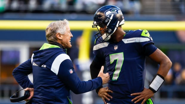 Seattle Seahawks head coach Pete Carroll, left, talks with quarterback Geno Smith (7) during a fourth quarter timeout against the New York Jets at Lumen Field.
