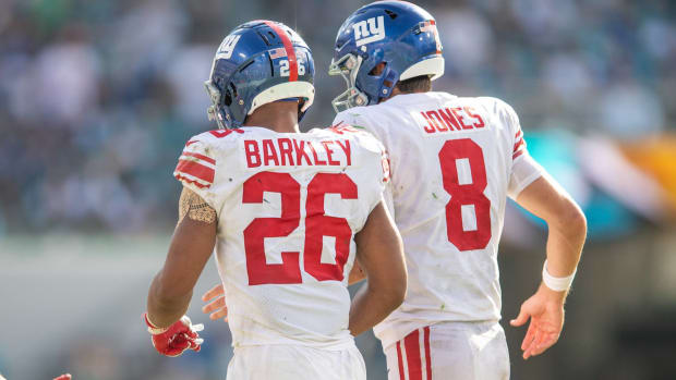 Giants quarterback Daniel Jones and running back Saquon Barkley celebrate a touchdown during a game.