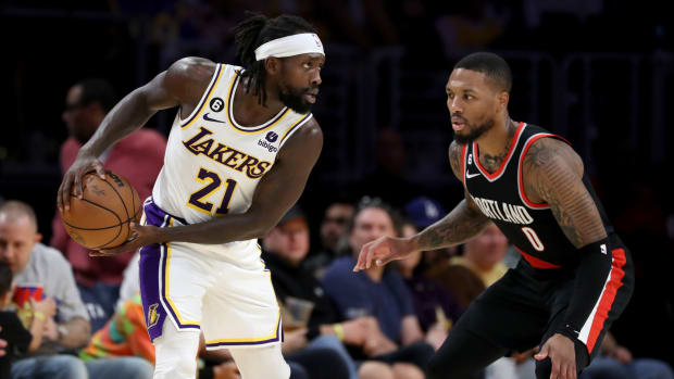 Lakers guard Patrick Beverley (21) is guarded by Trail Blazers guard Damian Lillard (0) during the first half of a game.