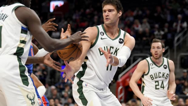 Milwaukee Bucks center Brook Lopez (11) passes the ball to guard Jrue Holiday (21) under the basket against the Detroit Pistons