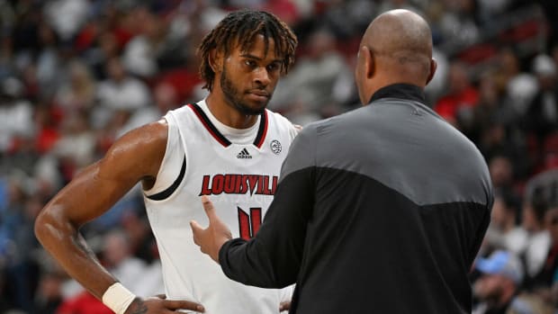 Louisville basketball player Roosevelt Wheeler speaks with coach Kenny Payne during a game