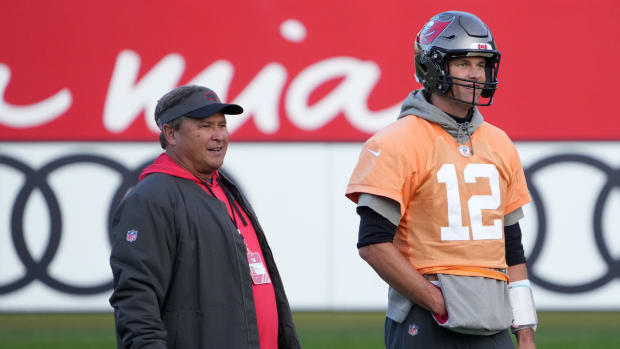 Nov 11, 2022; Munich, Germany; Tampa Bay Buccaneers quarterbacks coach Clyde Christensen (left) and quarterback Tom Brady (12) react during practice at the FC Bayern Campus.