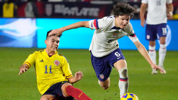 USMNT’s Paxten Aaronson carries the ball away from a defender vs. Colombia.