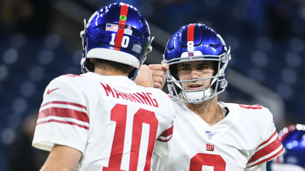 Giants quarterbacks Daniel Jones (8) and Eli Manning fist bump before a game against the Lions.