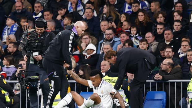Eder Militao pictured being helped up from the ground after sustaining an injury during Real Madrid's 2-0 win over Valencia in February 2023