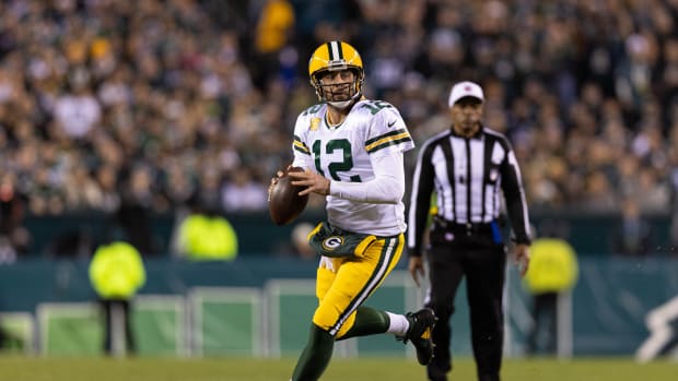 Green Bay Packers QB Aaron Rodgers throws pass on run
