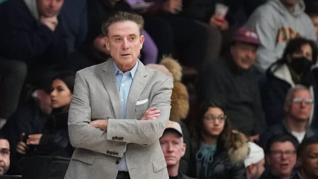 Iona coach Rick Pitino crosses his arms on the sideline