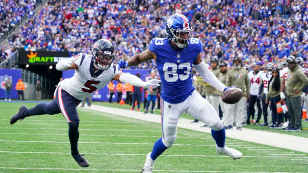 Nov 13, 2022; East Rutherford, NJ, USA; New York Giants tight end Lawrence Cager (83) scores a touchdown as Houston Texans safety Jalen Pitre (5) defends during the first quarter at MetLife Stadium.